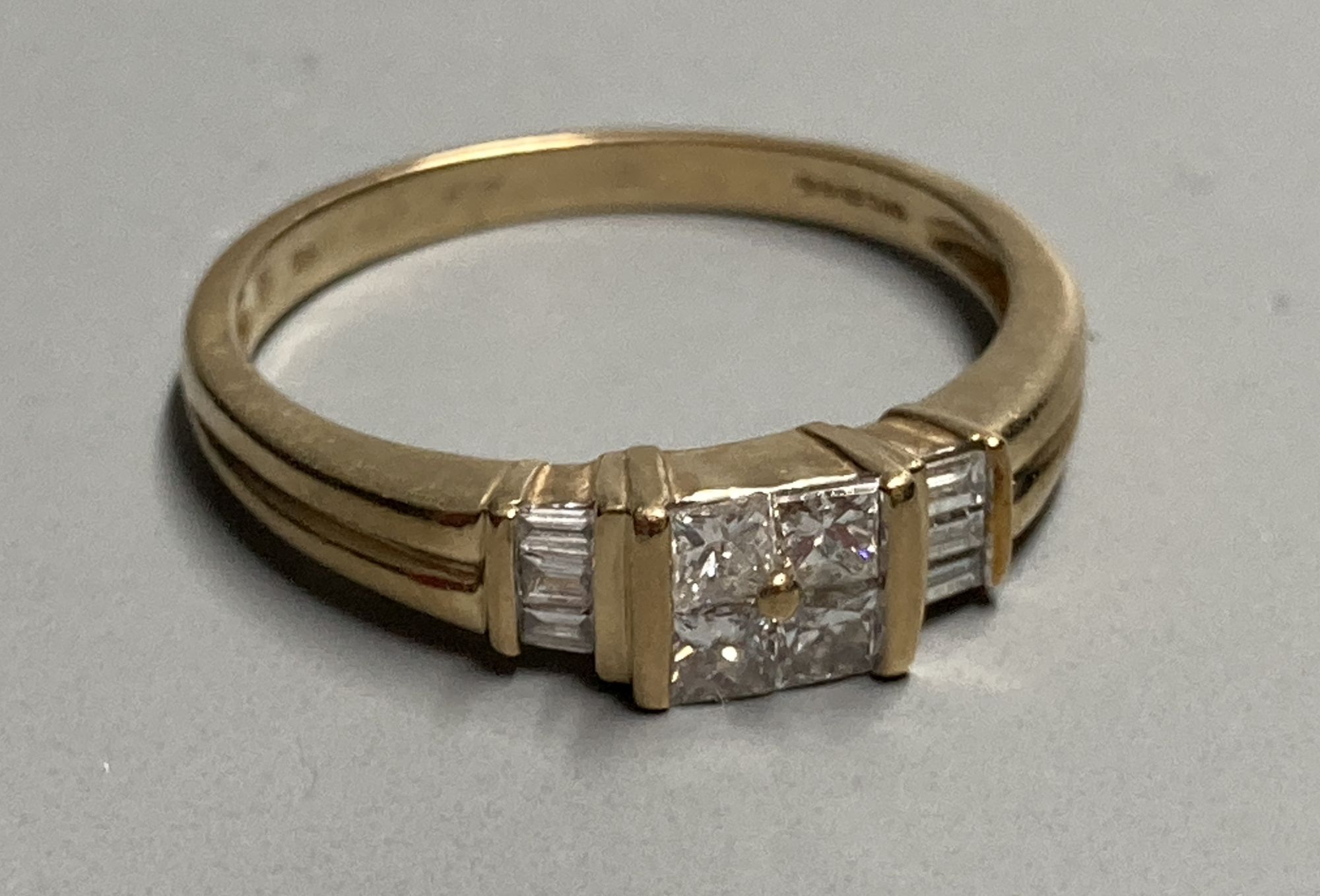 A modern 9ct gold and four stone princess cut diamond cluster ring, with six stone baguette cut diamond set shoulders, size S/R,